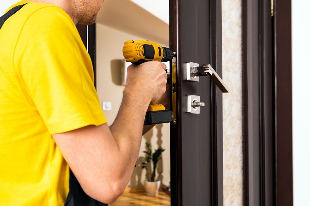 A,Man,Repairing,A,Doorknob.,Handyman,Repair,The,Door,Lock