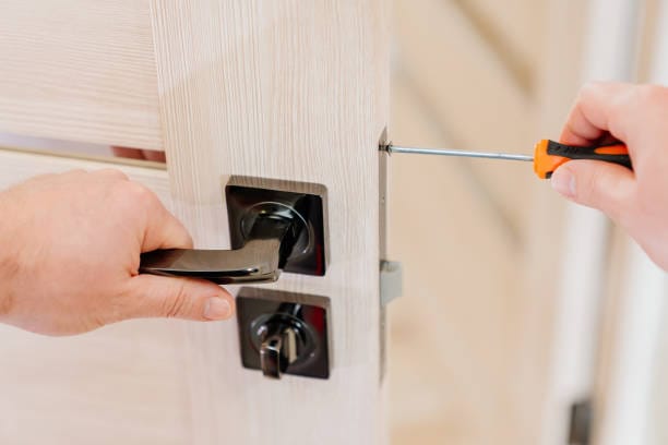 repairman repairs the door and installation of locks handles on entrance door-Locksmith service